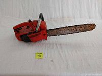 Full view of the red Power Sharp Craftsman chainsaw with rust visible on the blade and a yellow lot number 30 card in front
