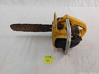 Side view of yellow McCulloch Mini Mac 30 chainsaw showing rusted cutting edge and general wear.