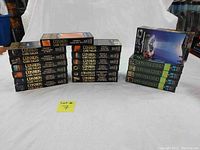 Wide shot showing all 19 VHS tapes including Cosmos series and UFO Diaries stacked neatly on a white backdrop