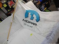 Mopar flag mounted on wooden pole, showing fabric and water stains