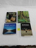 Lot of four nature books arranged side by side: Wild Animals, The Tree, Heart Waters, and Elk of North America