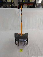 Ryobi rototiller attachment full front view showing metal tines and orange handle.
