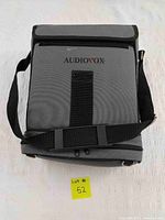 Gray Audiovox branded carrying case with shoulder strap on white background, showing front side.