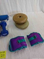 Purple and teal Everlast ankle/wrist weights, blue 5 lb Alex dumbbells, beige York weight plates stacked