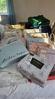 Overview of all packaged linens, slipcover and blankets on table