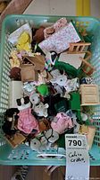 Overhead photo showing a large basket filled with multiple Calico Critters animal figures, miniature furniture pieces, and fabric accessories.