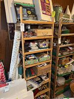 Wooden shelving organizer filled with various craft items and stacked canvas panels