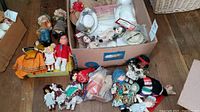 Overview of dolls and doll clothing including fabric dolls, plastic dolls, and boxed items