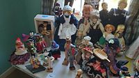 Wide view showing collection of dolls in various international costumes arranged on a table