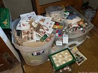 Bins filled with various Christmas ornaments, Merry Minis packages, glittery reindeer figurines, and small vintage boxes for storage.