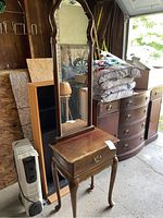 View of the wooden side vanity with tall mirror and single drawer. Visible scratches on the top surface and wood finish.