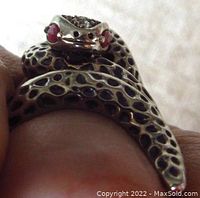 Close-up angle showing the snake's head with red ruby eyes and detailed textured silver body.