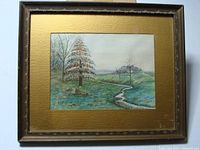 Framed watercolor landscape painting showing the whole scene including frame and mat under glass.
