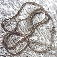 Flat lay photo of the long sterling silver box chain on lace background showing chain texture and clasp.