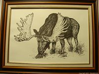 Full view of framed black and white print of moose grazing, signed by artist