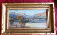 Full view of framed oil painting showing the scenic lake, village, and mountains.