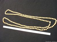 Full view of the pearl necklace showing its length and the number of pearls.