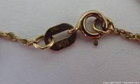 Close-up of the chain clasp showing markings '10K' stamped in two places on the clasp and ring.