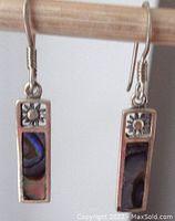Front view of pair of vintage sterling silver abalone dangle earrings showing rectangular abalone inlay and floral top design against white background.