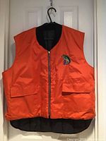 Orange sleeveless vest with zipper and pockets, fish emblem on chest