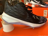 Side view of a black Nike Zoom Evidence 11 athletic shoe showing mesh upper, Nike swoosh, and white sole.