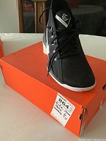 Men's Nike Zoom black athletic shoe size 6 resting on orange Nike box with lot tag.