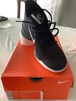 Men's Nike Zoom shoe displayed on orange Nike box showing size label men’s 6/women’s 7.5.