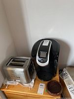 Photo showing Keurig 2.0 coffee maker and Breville toaster side by side on a wooden surface