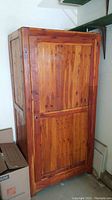 Closed cedar closet showing vertical slatted door with lock and natural wood finish.
