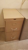 Full view of the beige Cole Steel metal filing cabinet showing two drawers and cabinet top.