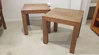 Two solid wood square side tables with visible surface scratches and marks on tops and legs.