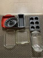 Overview of baking pans including silicone square pan, metal Bundt pan, loaf pan, muffin pan, wire cooling rack, and three glass baking dishes.