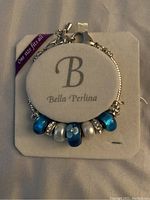 Bella Perlina bracelet with blue, silver, and crystal beads displayed on branded packaging showing 'B Bella Perlina' and 'One size fits all'.