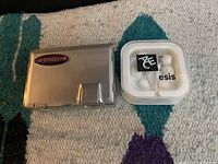 USB extender hub and white in-ear plug earphones in plastic case on carpet