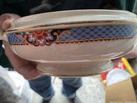 Side view of the serving bowl showing the blue floral border with gold accents around the rim and base.