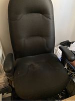 Front view of black executive chair showing cushioned seat and backrest with armrests.