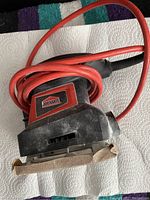 Job Mate hand sander showing the orange power cord and worn sanding base.