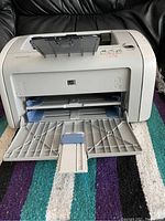 Front view of HP LaserJet 1020 printer showing paper trays and overall condition