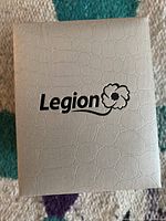 White textured box with embossed Legion logo and poppy symbol