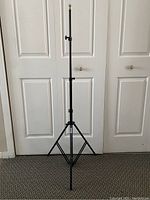 One Manfrotto Pro Stand tripod fully extended showing black metal construction and locking clamps.