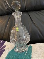 Full view of the Waterford crystal decanter placed on a sofa with stopper in place.