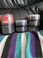 Photo of several stacks of blank writable CDs and DVDs including an Imation 100-pack CD-R spindle