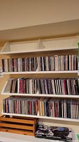 Wide view of multiple rows of CDs on shelves showing a large assortment of music CDs.