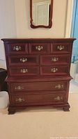 Full front view of tallboy dresser showing all six drawers and brass hardware
