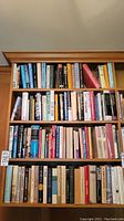 Bookshelves filled with hardcover books, showcasing a mix of subjects including some historical and literary titles.