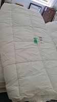 Full view of the white king-size duvet with square quilted pattern on a bed.