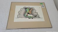 Full view of framed and matted limited edition print featuring a stylized bird with cloud-like background and clear framing details.
