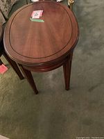 View of two oval side tables placed adjacent showing shape, height, legs, and finish