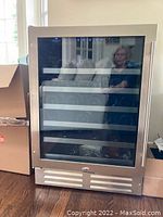 Front view of stainless steel door with tinted glass showing five metal shelves inside