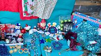 Overall collection of various Christmas decorations displayed on a blue surface and background, including ornaments, figurines, and other holiday items.